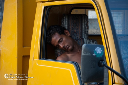 Truck driver sleeping inside truck